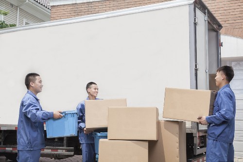 Professional movers carrying furniture through a Hackney street